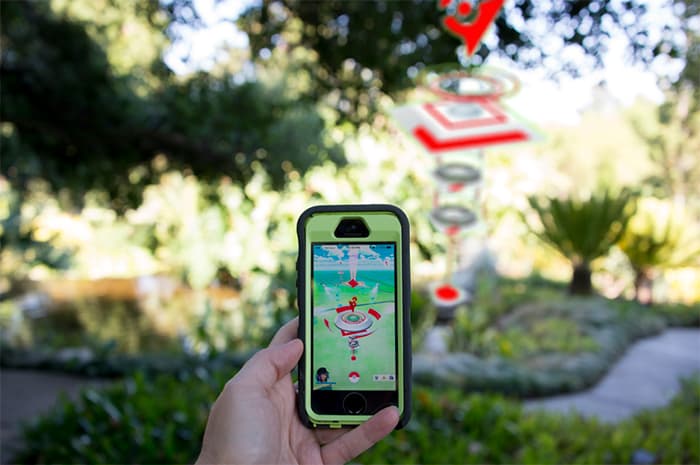 hand with iphone playing pokemon go